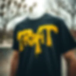 A close-up of a black and yellow t-shirt with graffiti art in a skate park setting