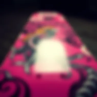 Close-up of a pink skateboard deck showcasing intricate designs