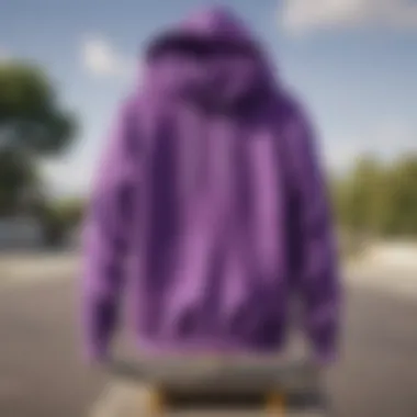 A vibrant purple hooded sweatshirt hanging on a skateboard